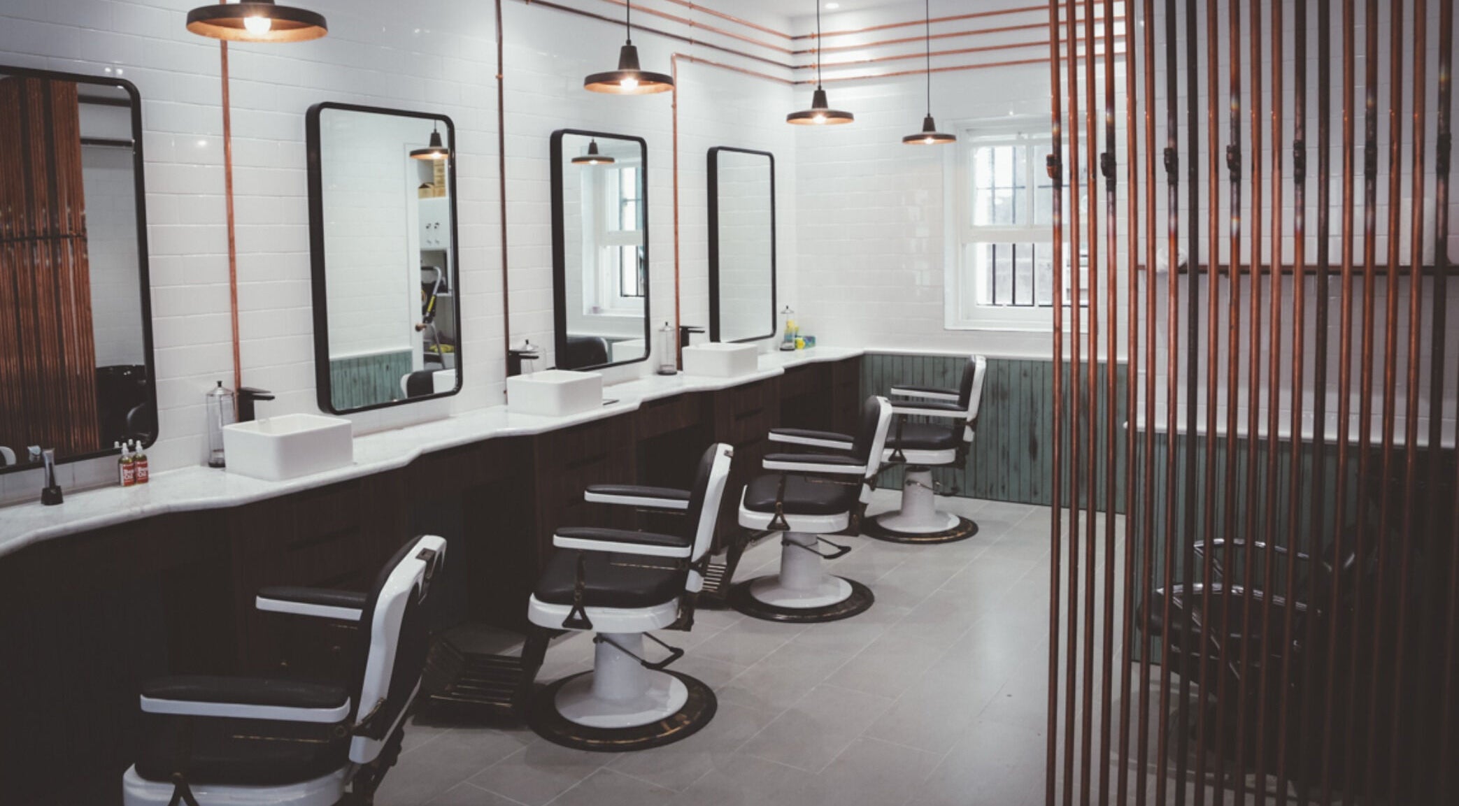 Sleek and modern interior of Alpha Barbers - Flinders Lane in Melbourne, Victoria, AU with stylish barber chairs.
