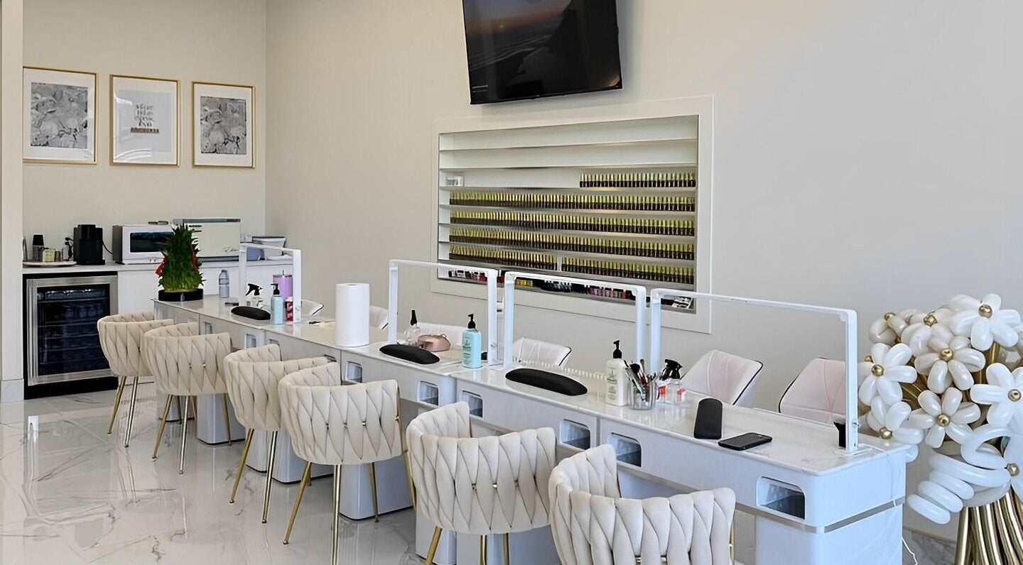 Modern nail salon interior at La Crème Nail Bar in Leduc, Alberta, CA, featuring plush chairs and elegant decor.
