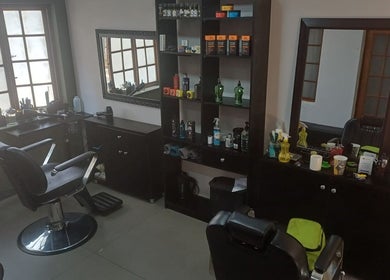 Interior of Meneer Barbershop in Boksburg, Gauteng, ZA featuring modern barber chairs and product display.