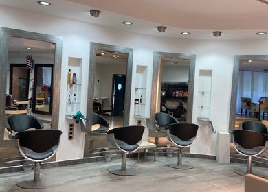 Interior moderno de Studio De Belleza Virginia Falcao en Cambrils, Catalunya, ES con sillas y espejos elegantes.