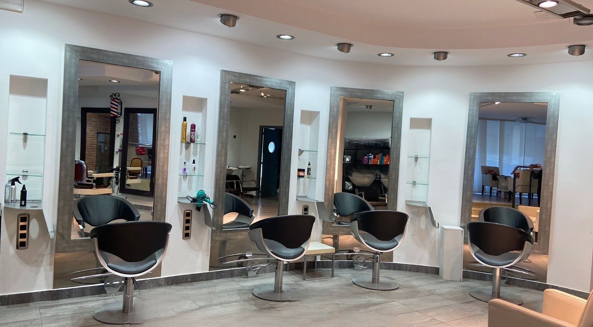 Interior moderno de Studio De Belleza Virginia Falcao en Cambrils, Catalunya, ES con sillas y espejos elegantes.