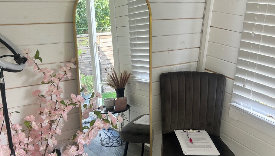 Cozy corner at Maisy’sBeautyBarn, Headcorn, England, with mirror, chair, and floral decor.