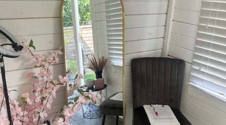 Cozy corner at Maisy’sBeautyBarn, Headcorn, England, with mirror, chair, and floral decor.