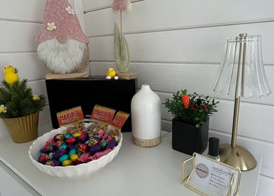 Charming decor corner at Maisy’sBeautyBarn in Headcorn, England, GB with candies, ornaments, and a lamp.