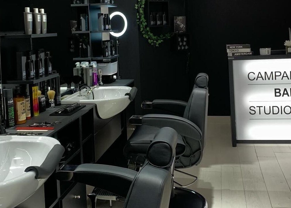 Interno moderno di CAMPANA BARBER STUDIO, Andria, Puglia, IT con sedie eleganti e prodotti per capelli.