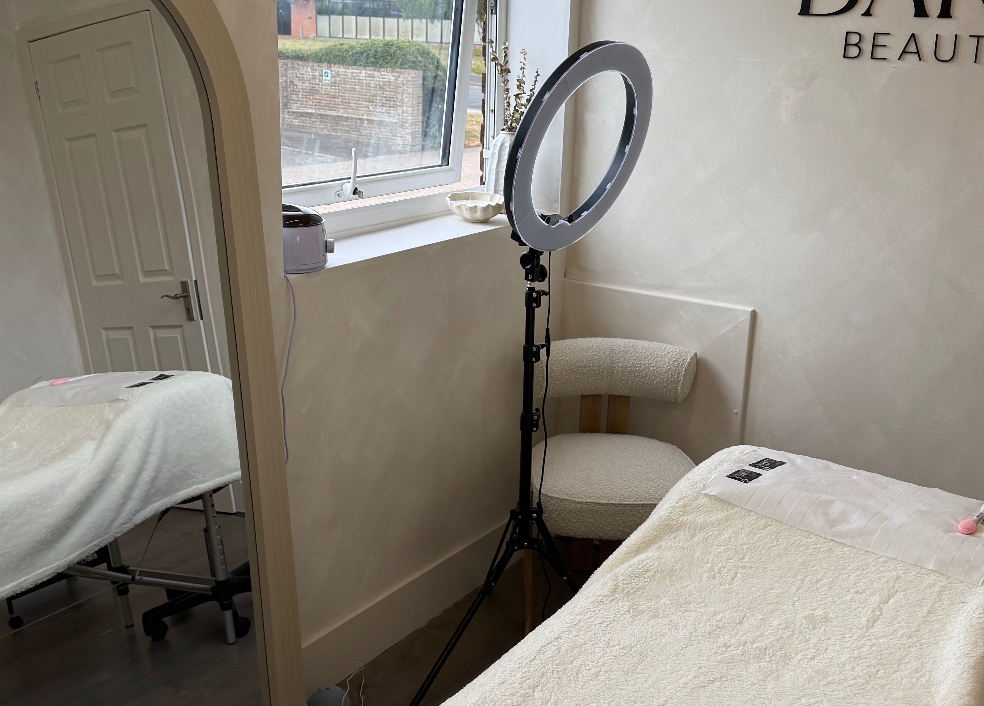 Serene treatment room at Bare Beauty by Vici, Andover, England. Plush bed, elegant décor, inviting relaxation.