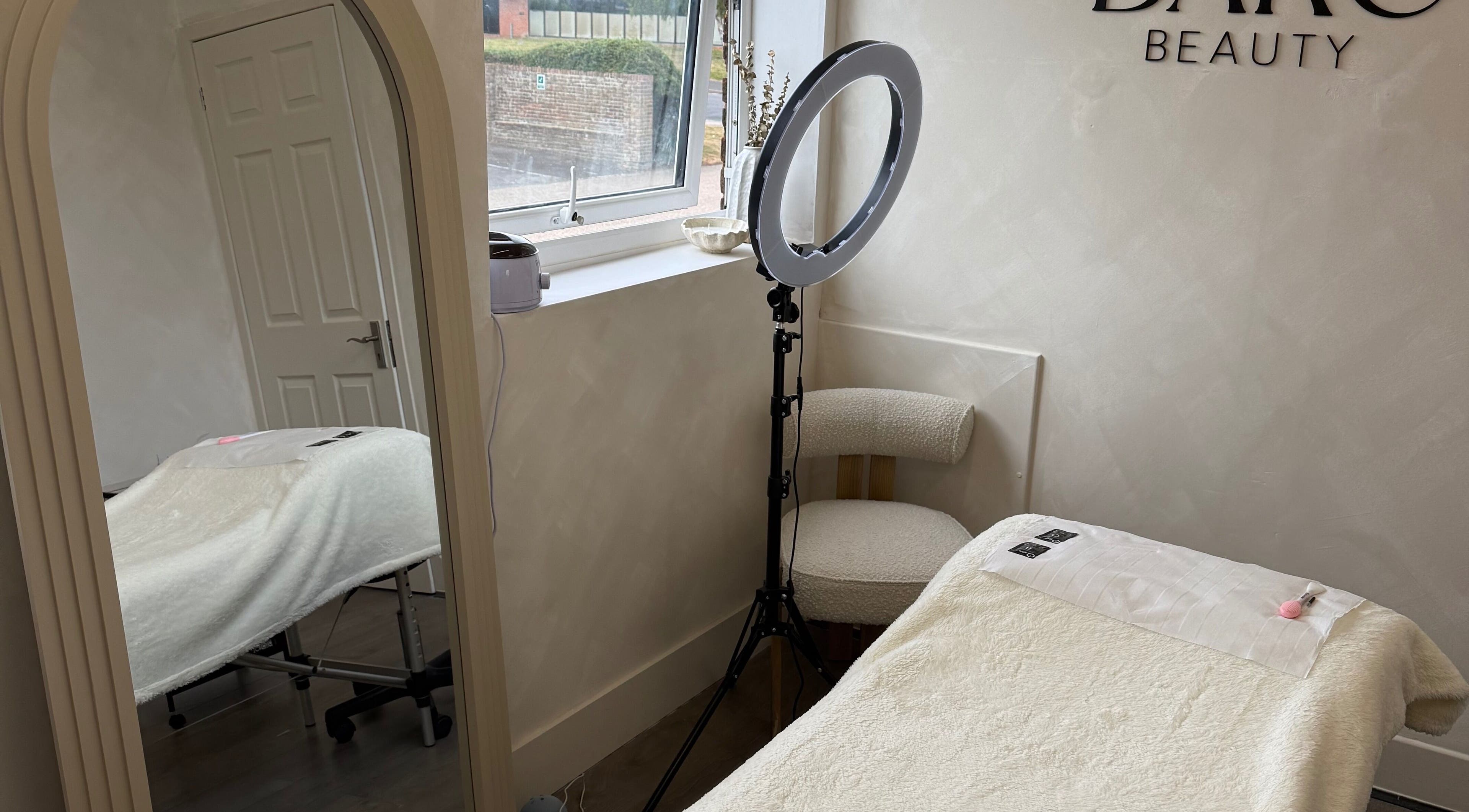 Serene treatment room at Bare Beauty by Vici, Andover, England. Plush bed, elegant décor, inviting relaxation.