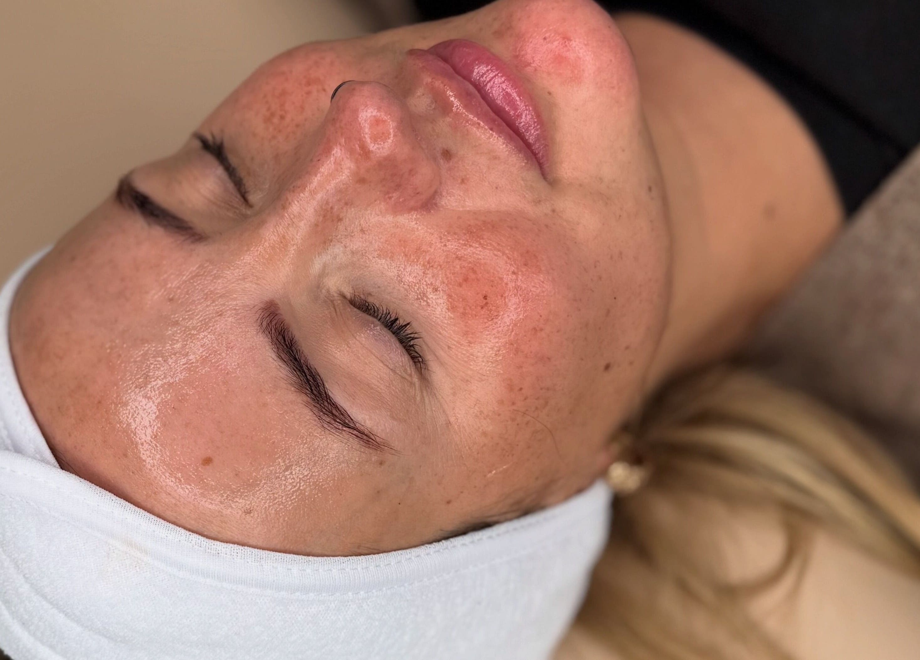 Woman enjoying a facial treatment at Bare Beauty by Vici in Andover, England, GB. Calm and refreshed appearance.