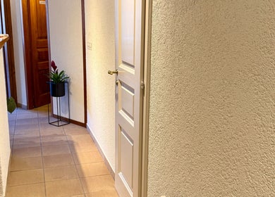 Couloir intérieur de MTC Eglantine, Morges, Vaud, CH avec plante décorative et porte blanche.