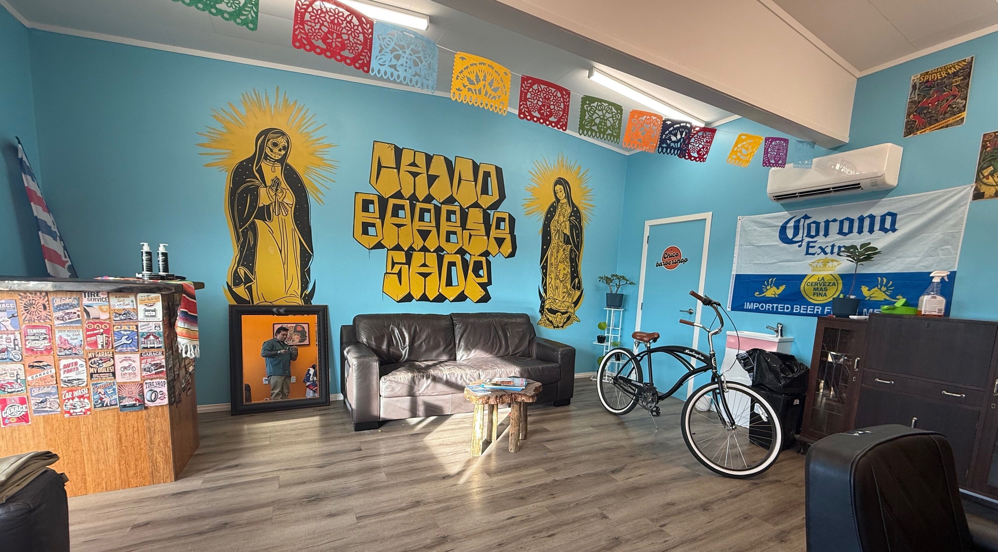 Chico Barbershop interior in Whanganui, NZ features colorful decor and rustic charm with vibrant wall art.