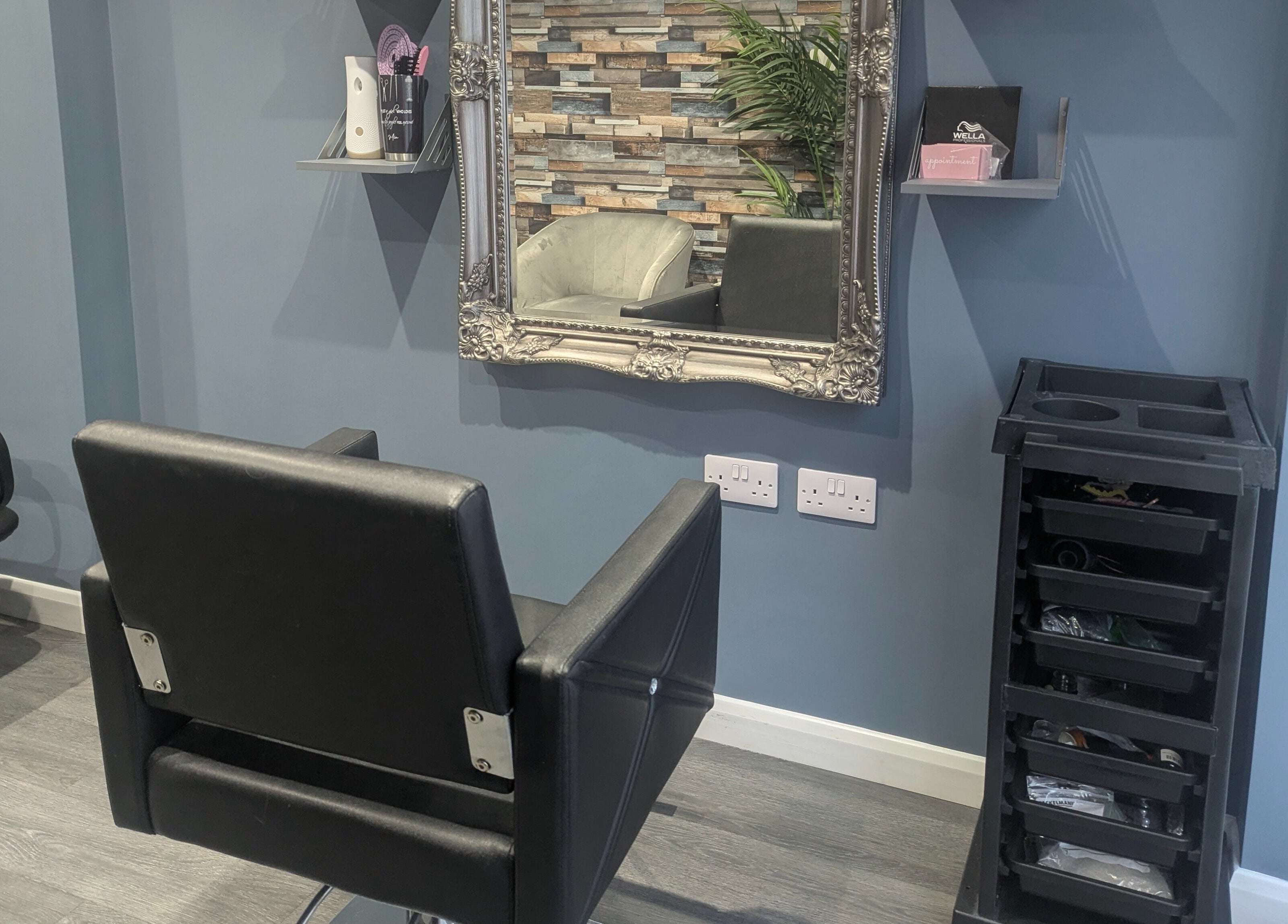 Chic salon interior at Hair By Mia in Carlisle, England, featuring a modern styling chair and ornate mirror.