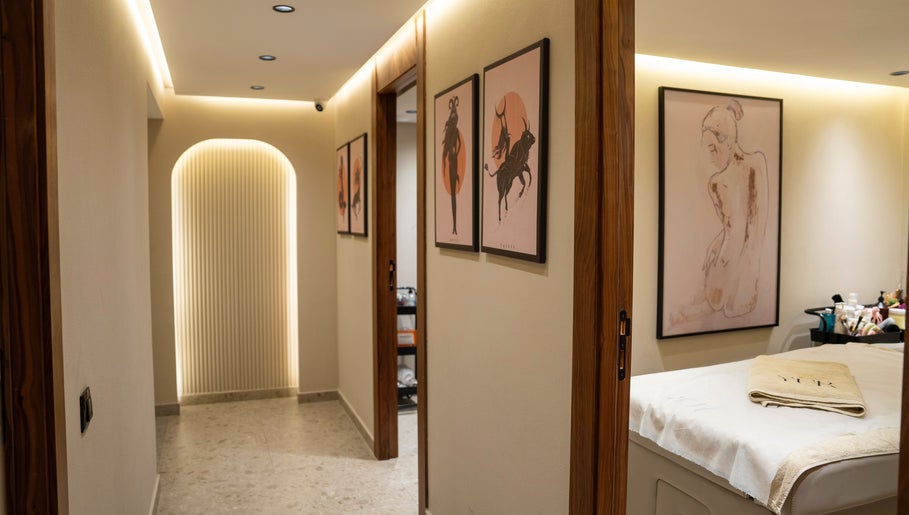 Intérieur élégant de Yur maison de beauté à Casablanca, MA, présentant des œuvres d'art murales et une table de massage.