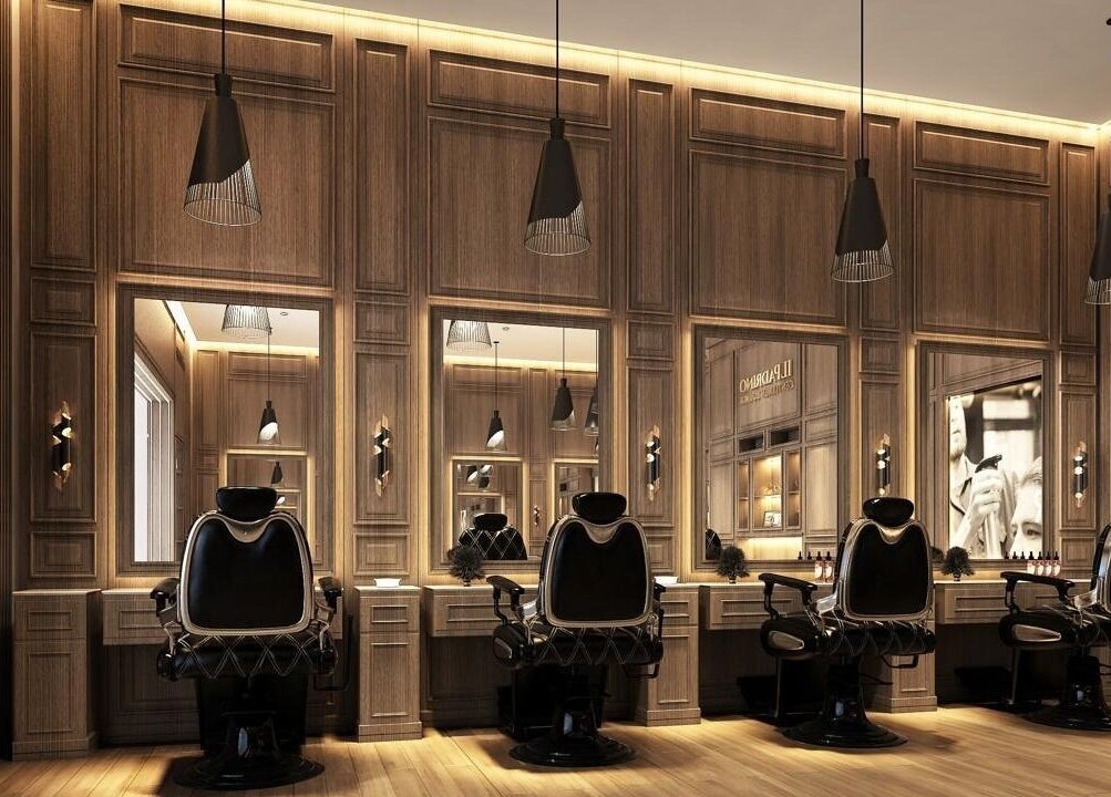 Luxurious barber chairs at Il Padrino Gentlemen Lounge, Meadows Village, Dubai, AE, in an elegant wood-paneled room.