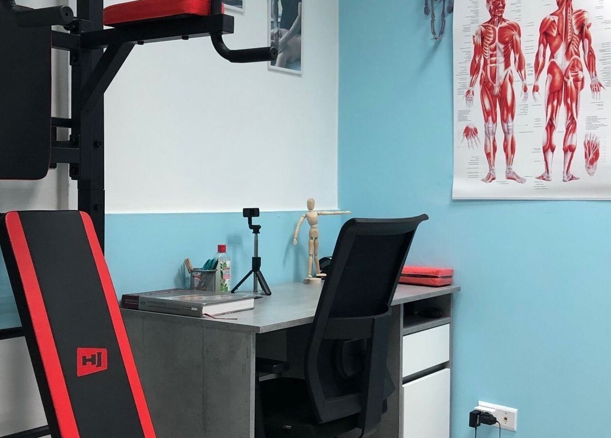 Кабинет IDMassage в Варшаве с анатомическим плакатом и тренажером.
