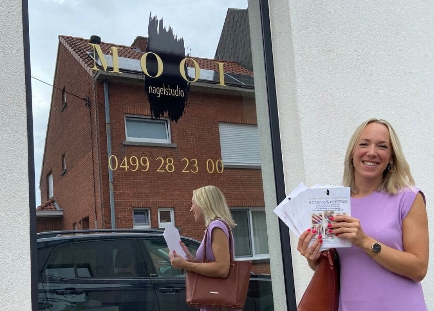 Vrouw voor Instituut Mooi in Kortenberg, Vlaams Gewest, BE met promofolders.