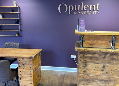 Reception at Kai @ Opulent Hair & Beauty in Cudworth, England, GB with wooden furniture and purple walls.