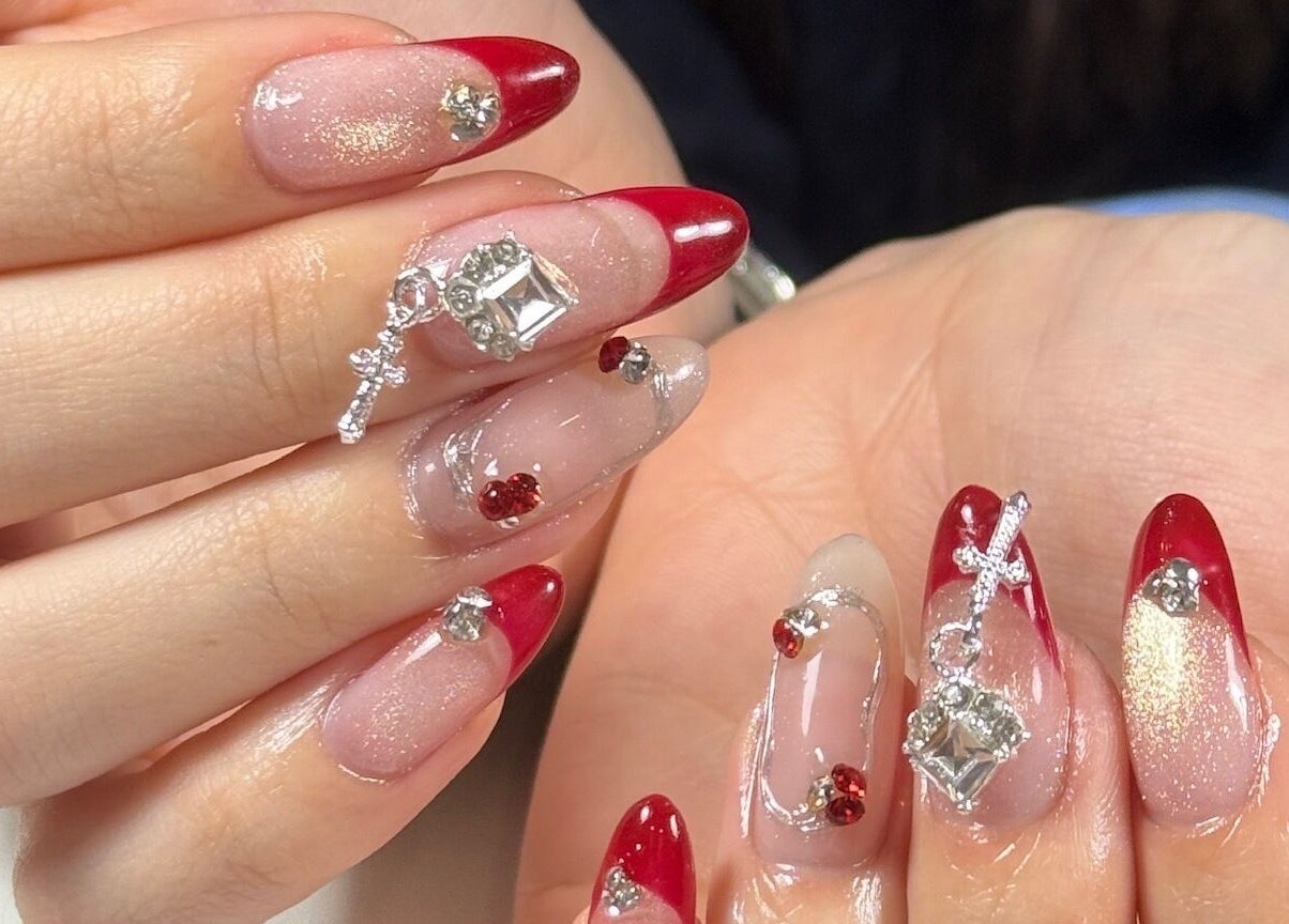 Elegant gem-studded nail art in red and gold at Tipsy By Lexie, Montréal, Québec, CA.