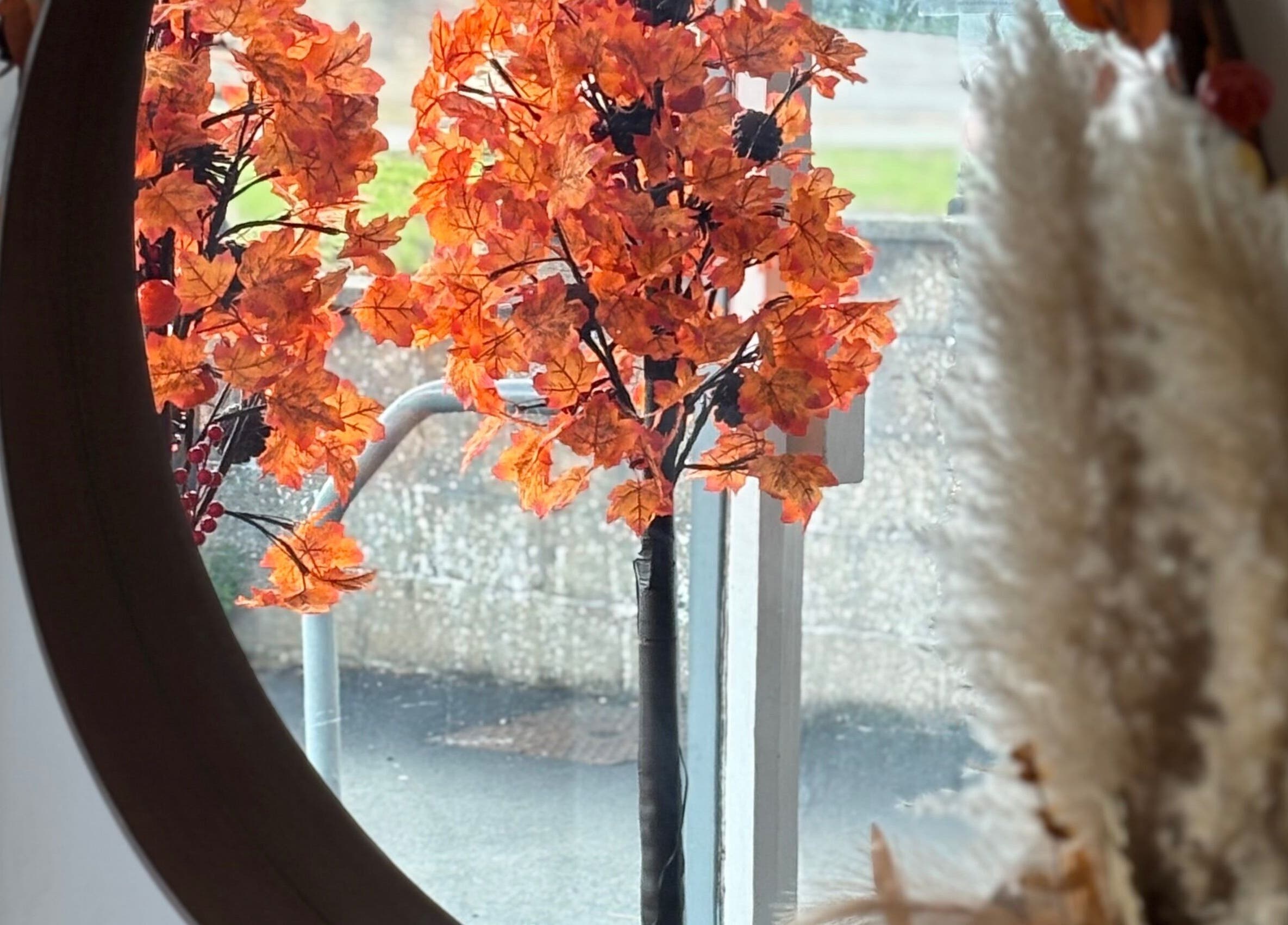 Elegant autumn decor at Perfection, Swindon, England, GB, with vibrant orange foliage mirrored beautifully.