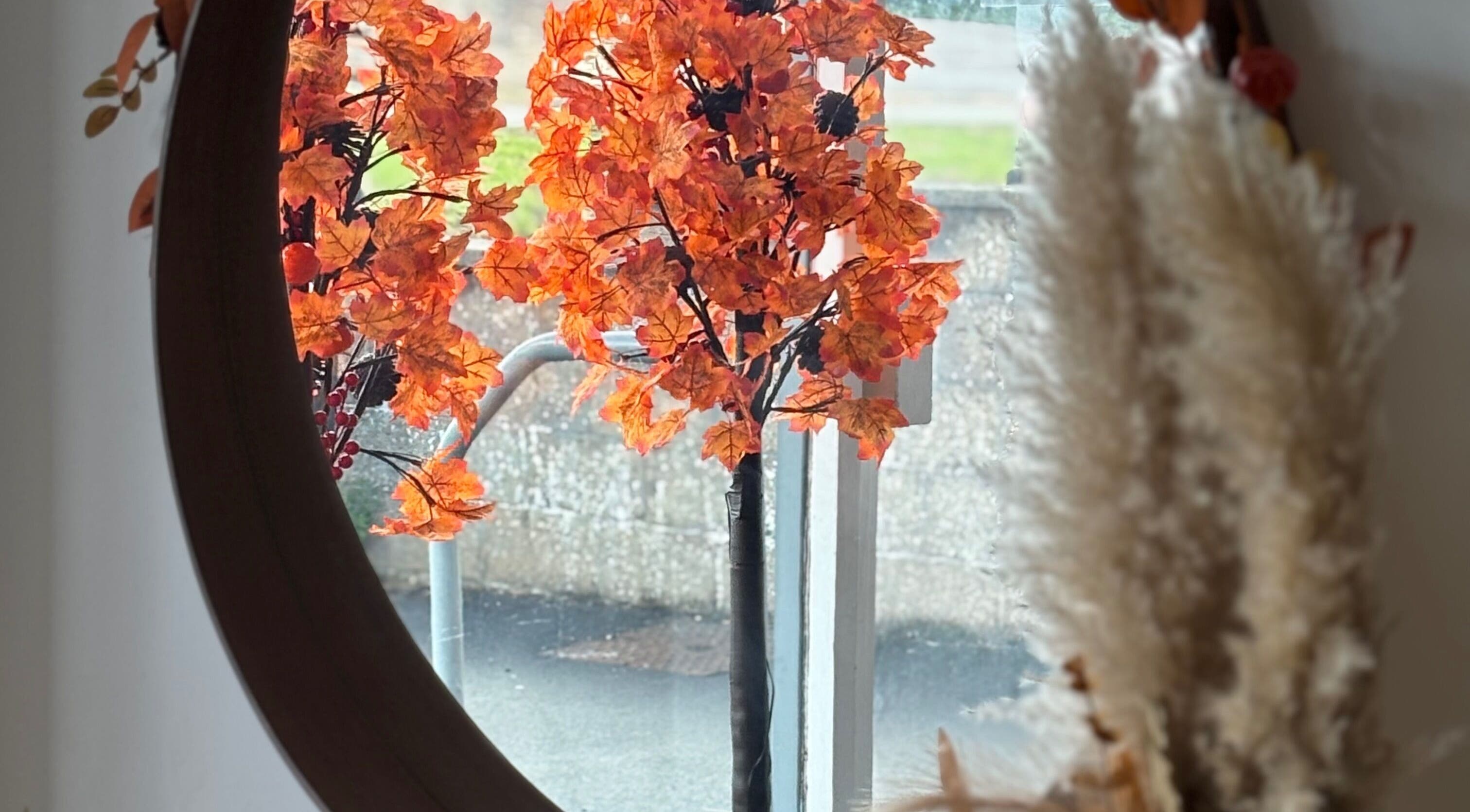 Elegant autumn decor at Perfection, Swindon, England, GB, with vibrant orange foliage mirrored beautifully.