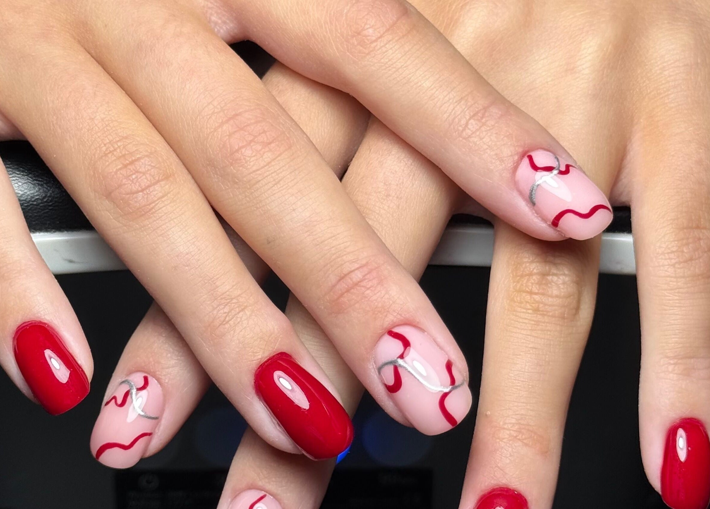 Intricate nail art with red waves at The Flying Nail Tech in Middlewich, England, GB.