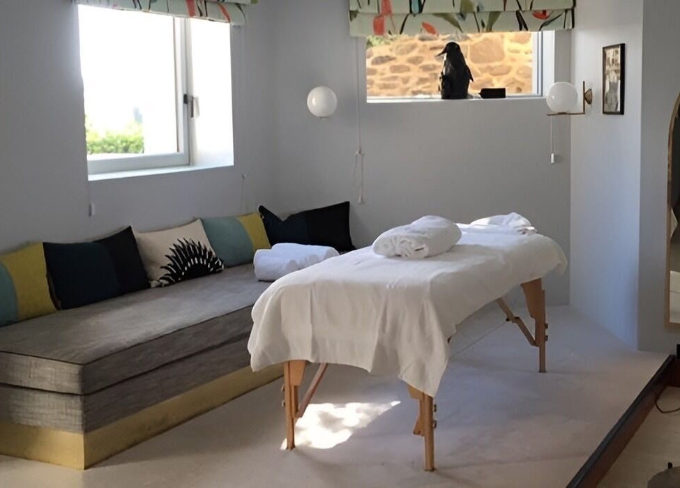 Salle de massage relaxante à Le Studio Mass'Fly Paris, Paris, Île-de-France, FR avec table et coussins.