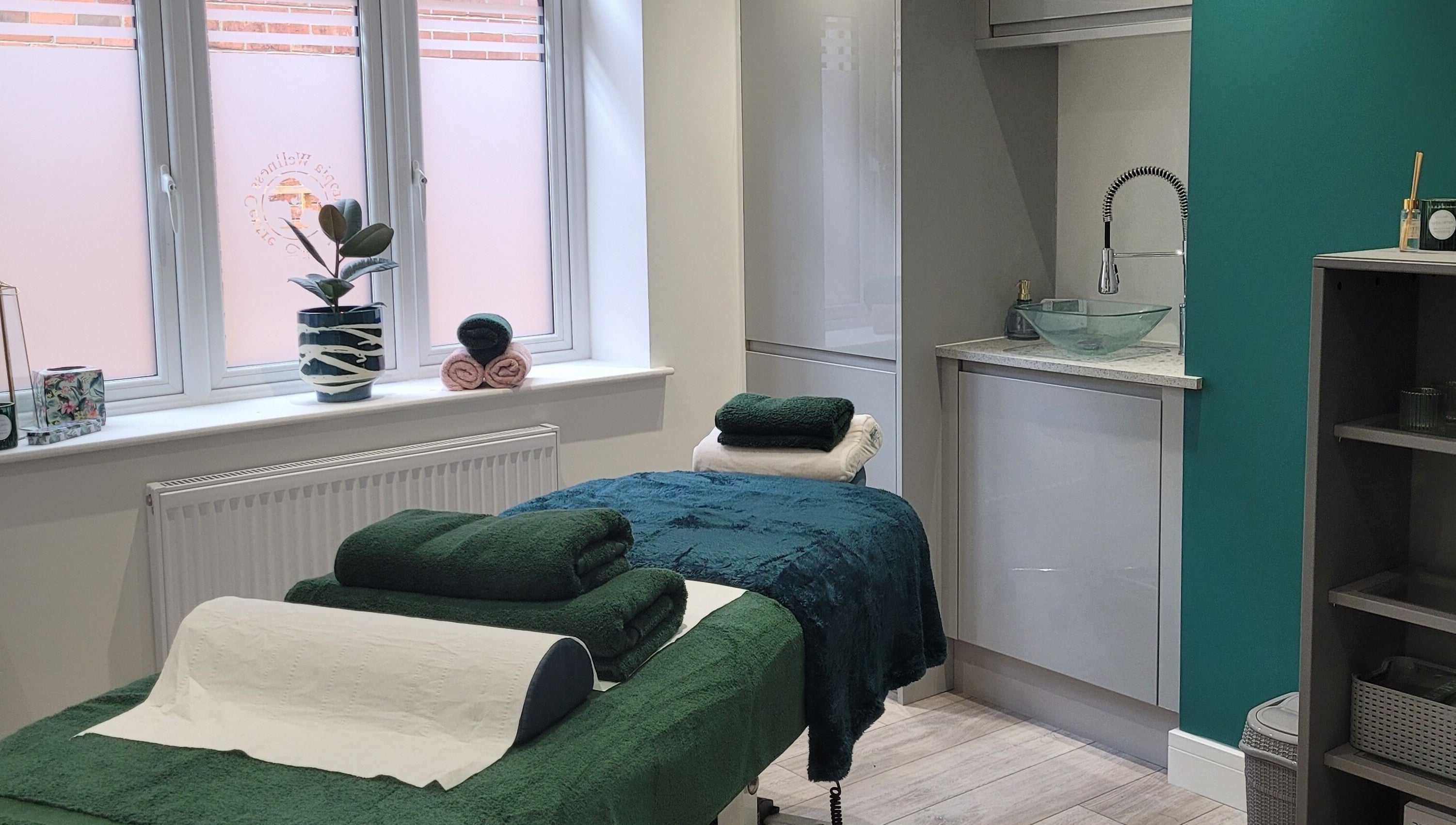 Massage room at Thrive Wellness Centre in Southampton, England, GB, featuring a tranquil setup with green towels.