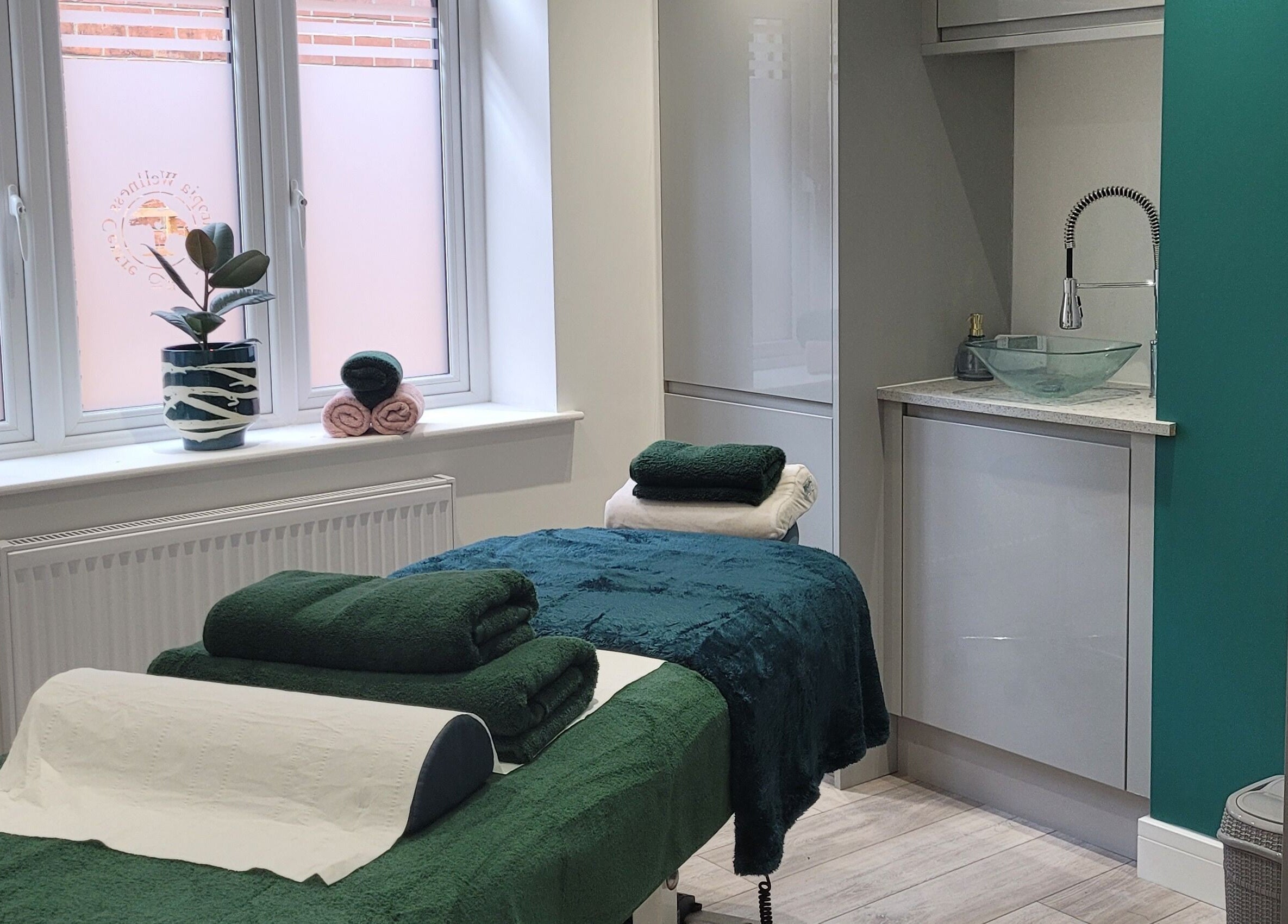 Massage room at Thrive Wellness Centre in Southampton, England, GB, featuring a tranquil setup with green towels.