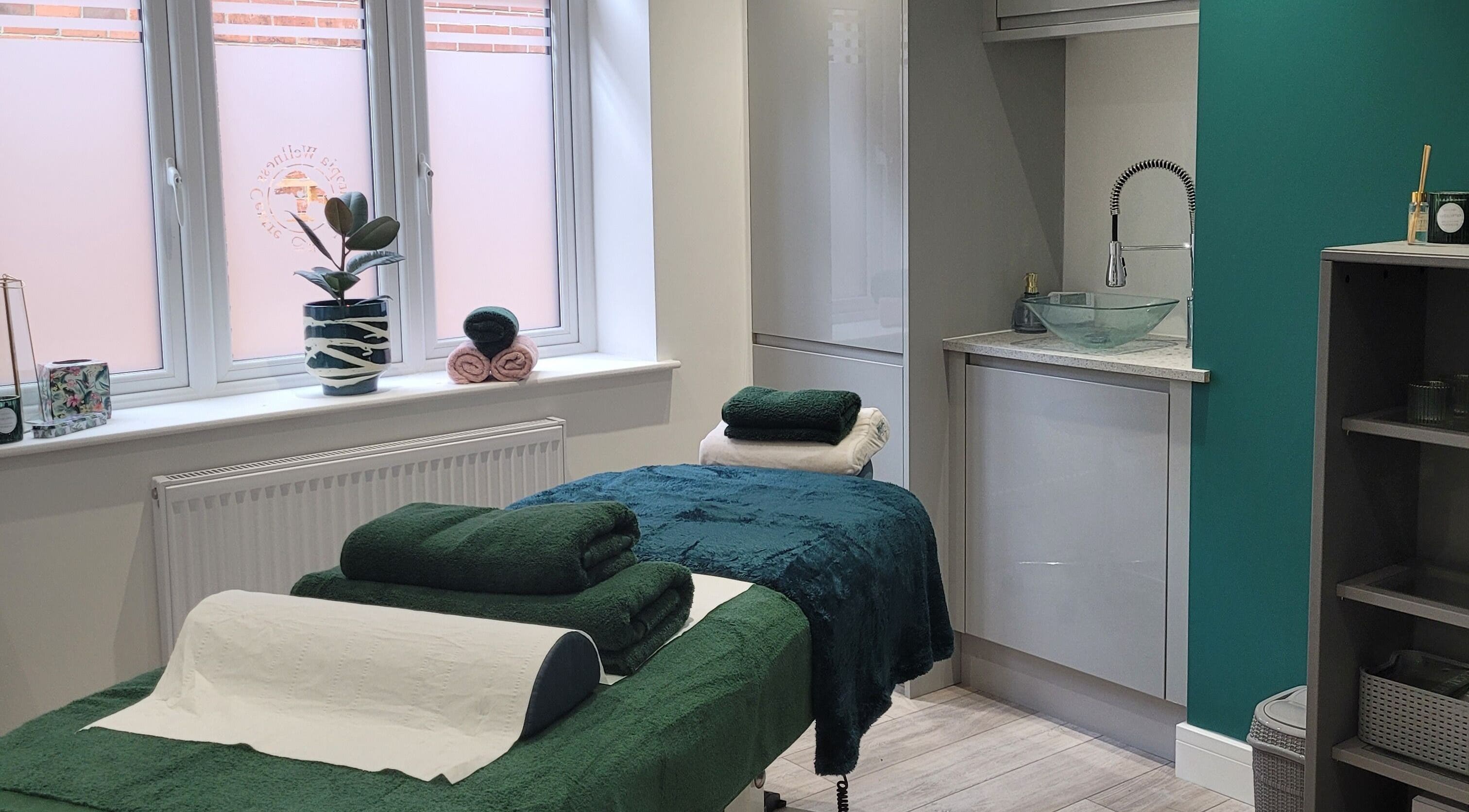 Massage room at Thrive Wellness Centre in Southampton, England, GB, featuring a tranquil setup with green towels.