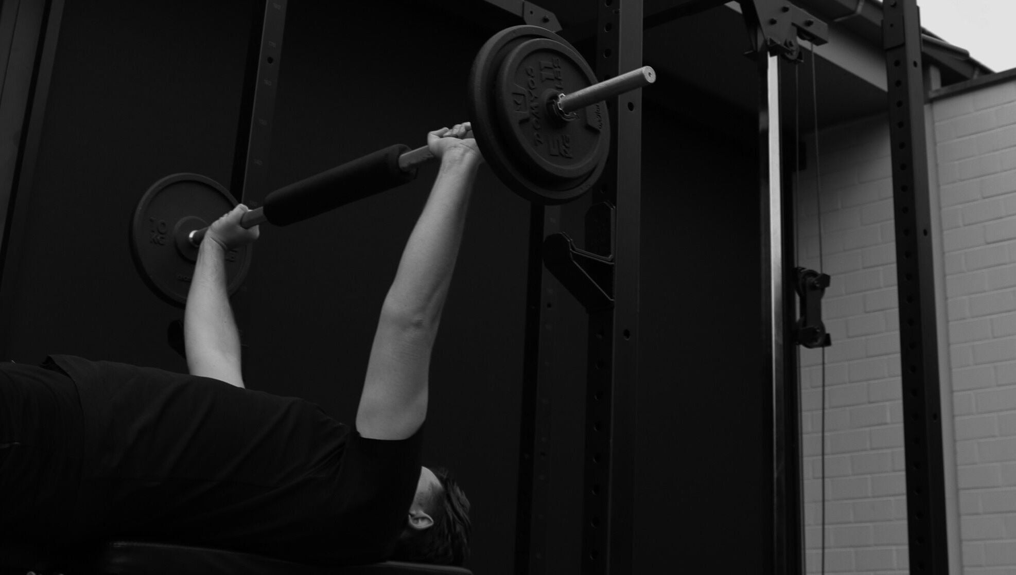 Man doet bench press bij Seppt, Eeklo, Vlaams Gewest, BE, met gewichten in een moderne fitnessruimte.