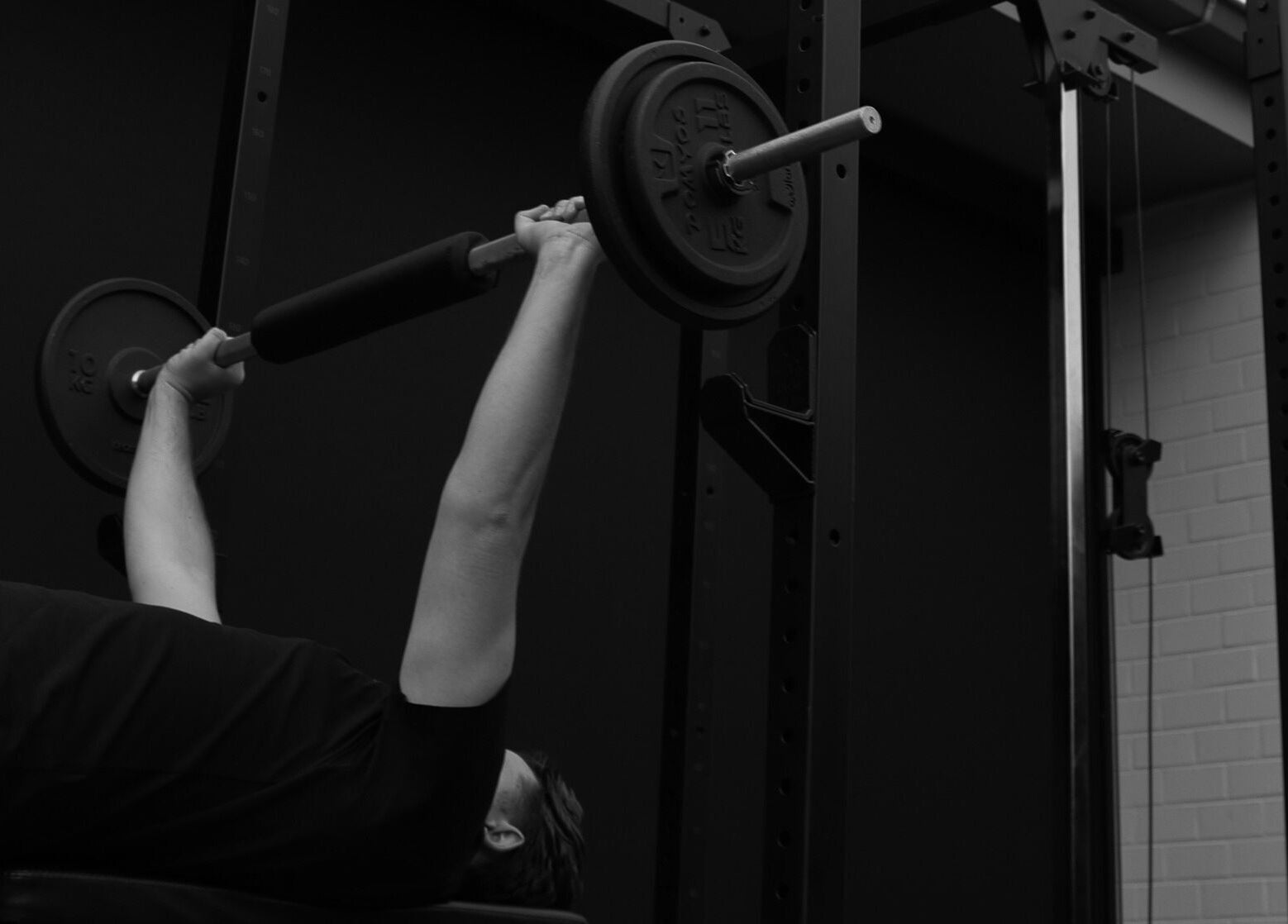 Man doet bench press bij Seppt, Eeklo, Vlaams Gewest, BE, met gewichten in een moderne fitnessruimte.