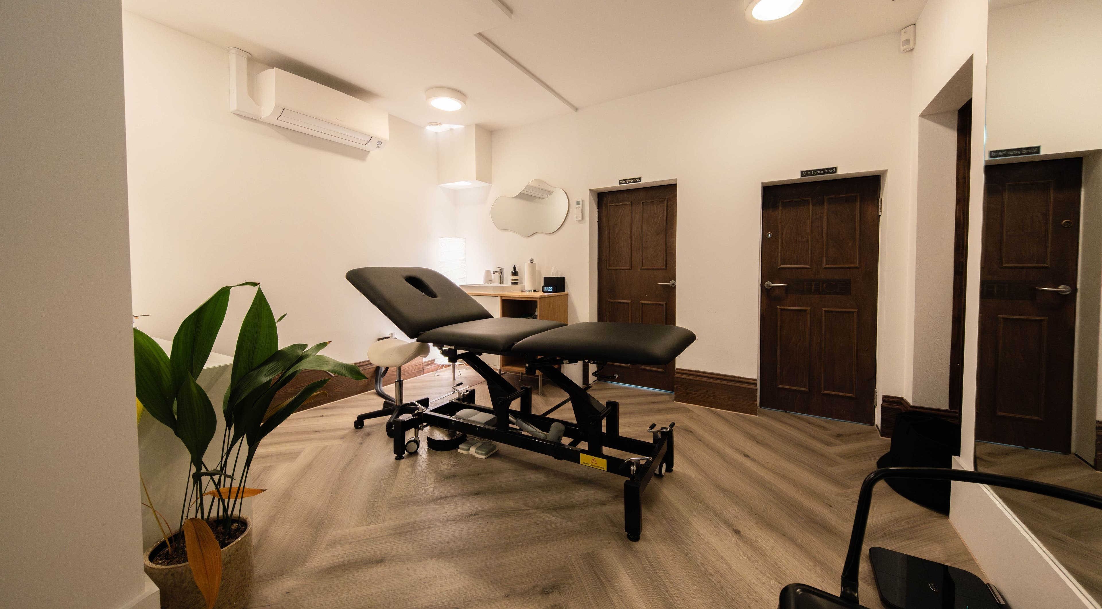 Tranquil therapy room at MAD, London, England, GB, featuring a plush massage bed and soothing decor.