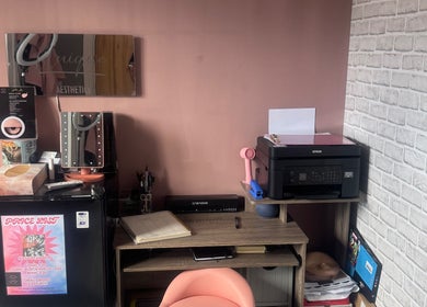 Cozy workspace at Unique Aesthetics, Ironville, England, featuring a vanity mirror, printer, and decor.
