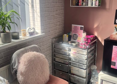 Cozy beauty corner at Unique Aesthetics, Ironville, England, GB showcasing skincare products and soothing decor.