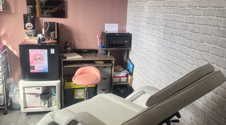 Interior of Unique Aesthetics in Ironville, England showing a treatment chair and work desk.