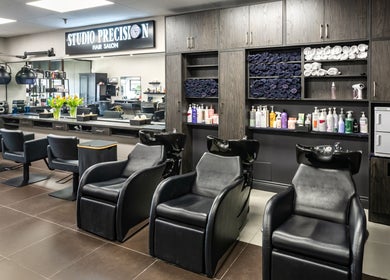 Modern interior of Studio Precision Hair Salon in Burlington, Ontario, CA, featuring elegant styling chairs and products.