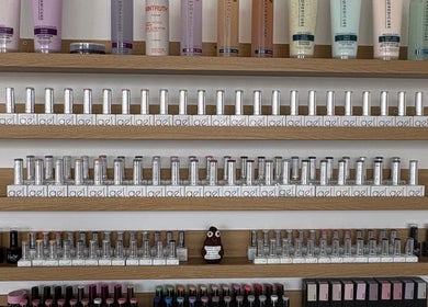 A variety of nail polishes and beauty products displayed on shelves at EmHanced Nails, Shipley, England, GB.