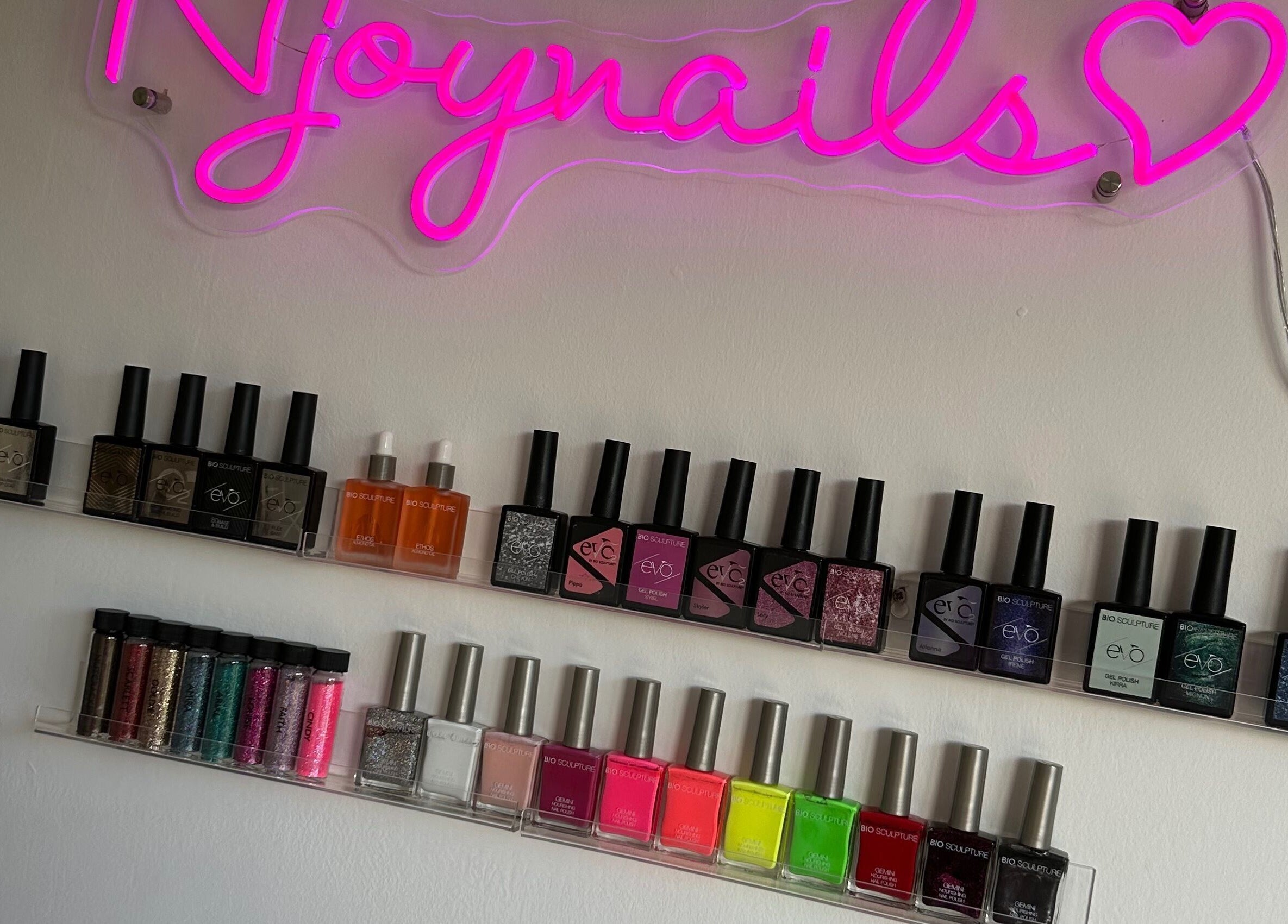 Colorful nail polish display at Njoynails, Stanbridge, England, GB showcasing a variety of shades.