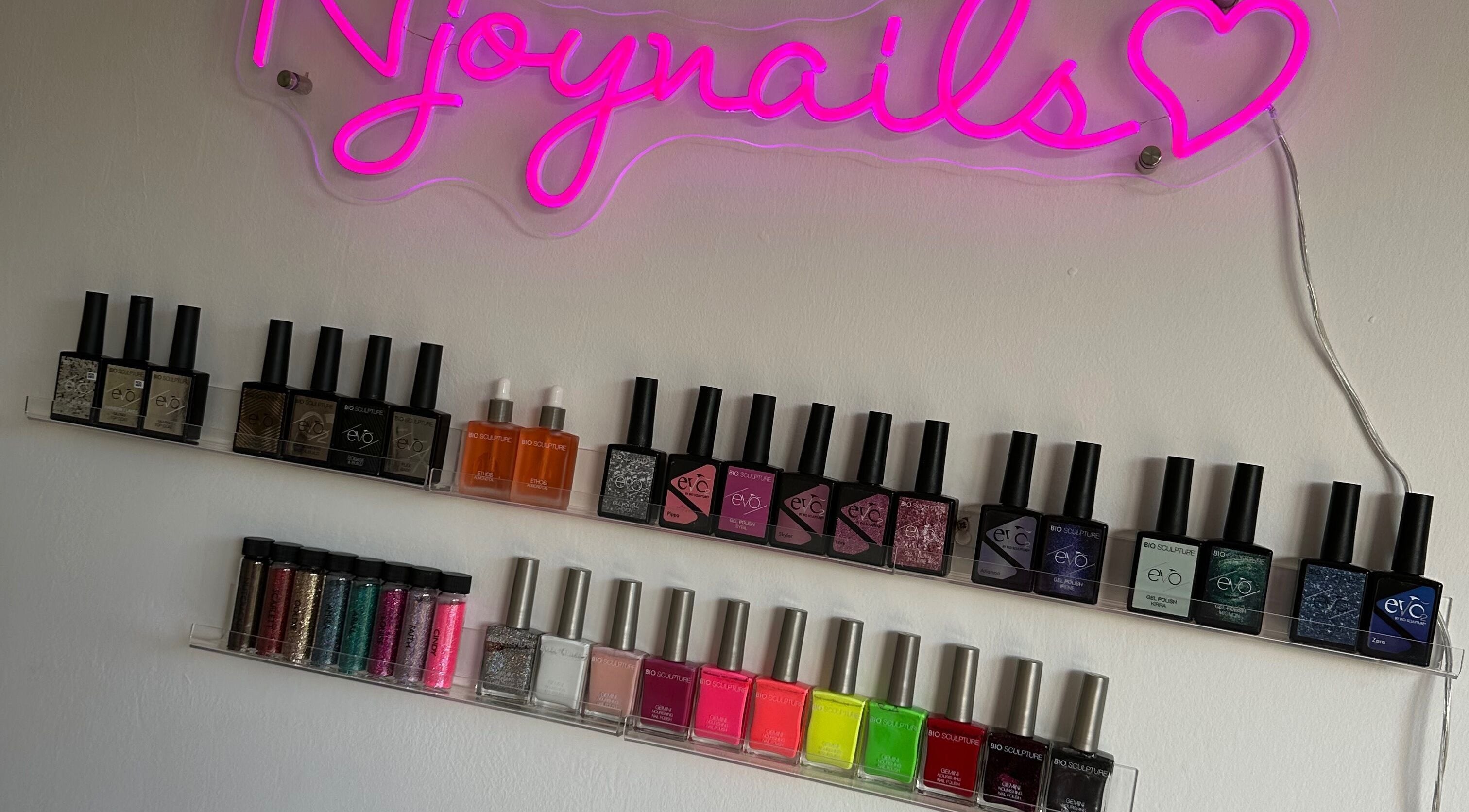 Colorful nail polish display at Njoynails, Stanbridge, England, GB showcasing a variety of shades.