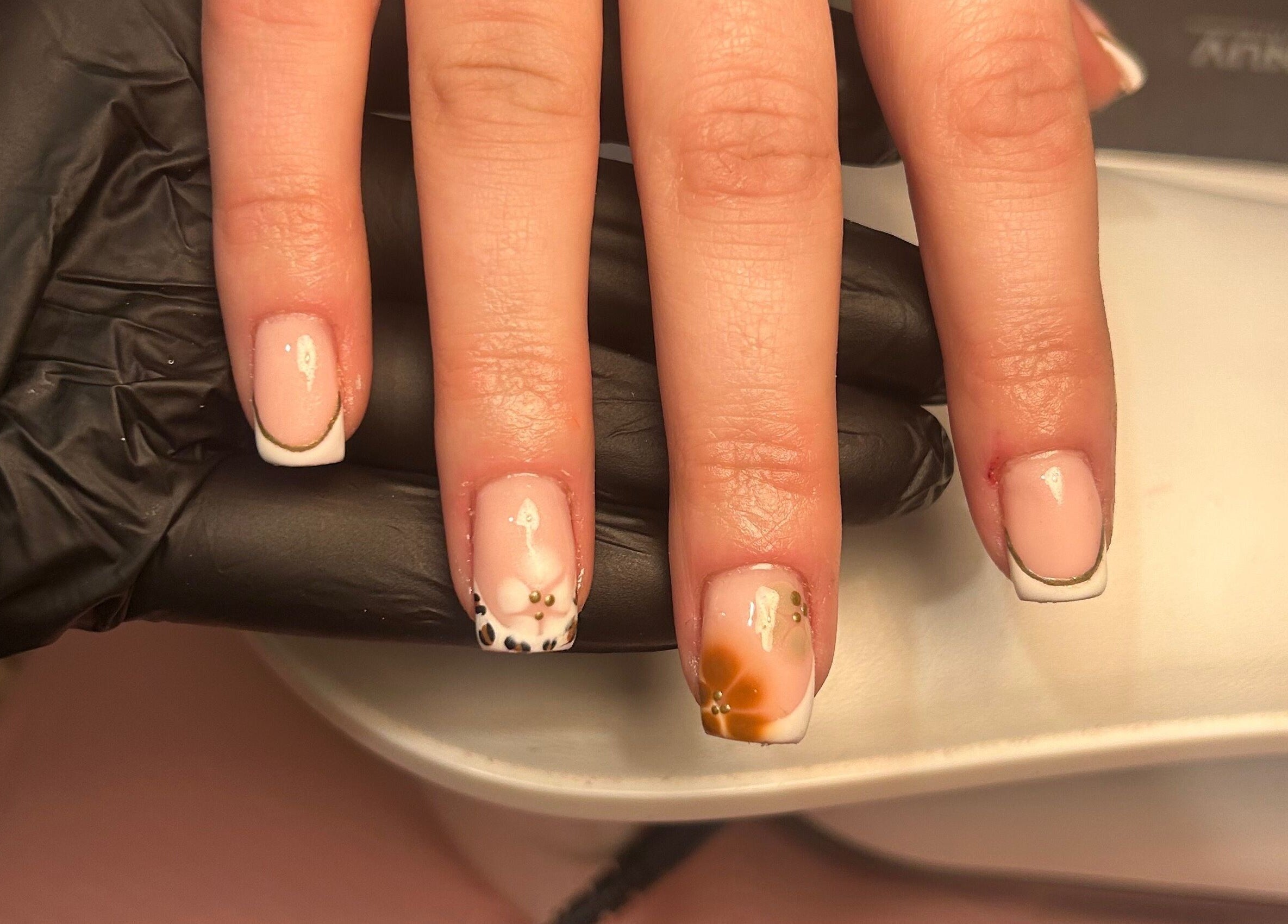 Elegant floral and French tip nails at Nails by Court, Cardiff, Wales, GB. Intricate detail for stunning manicure.