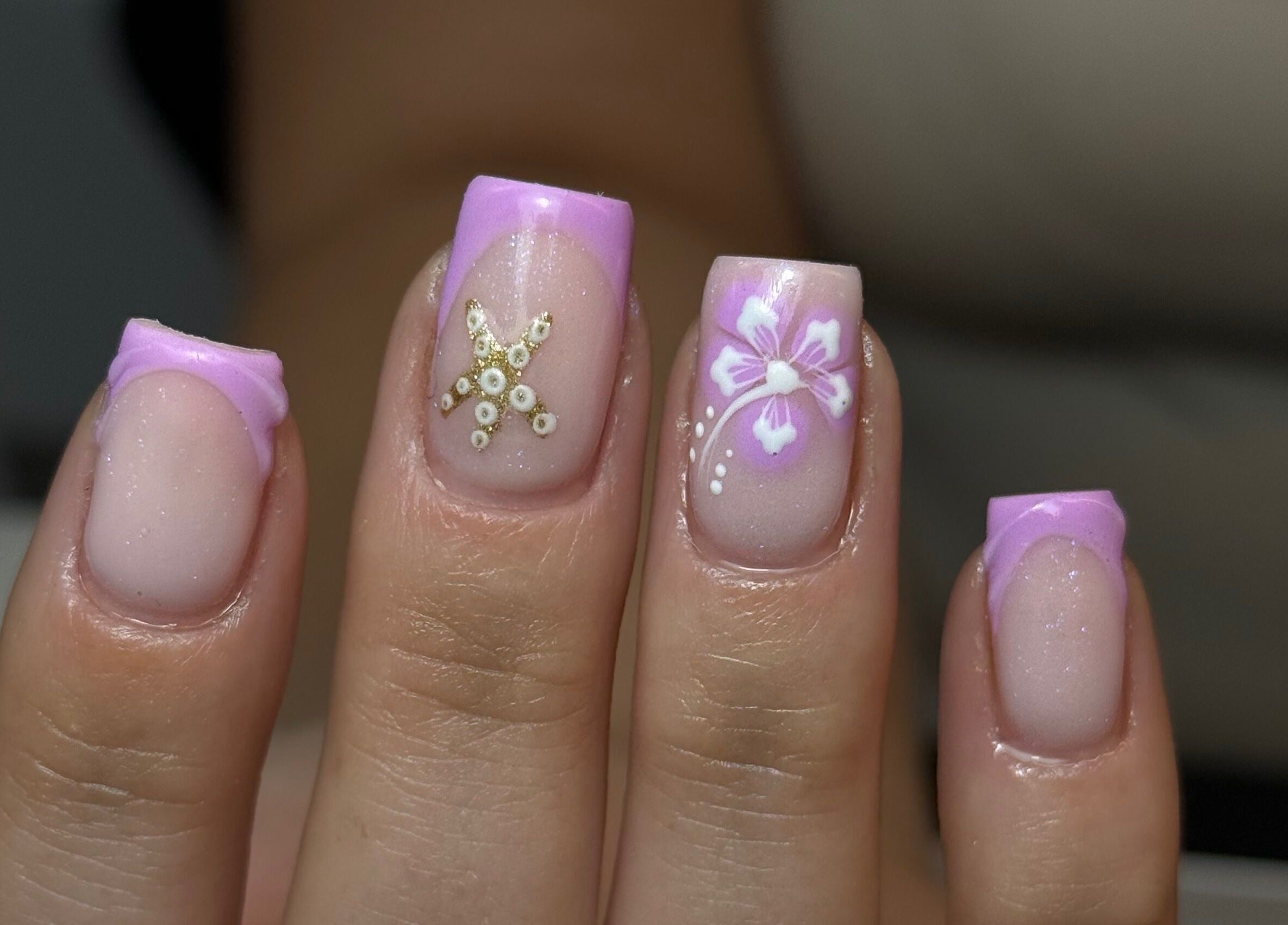 Elegant nail art featuring pink tips with floral designs at Nails by Court, Cardiff, Wales, GB.