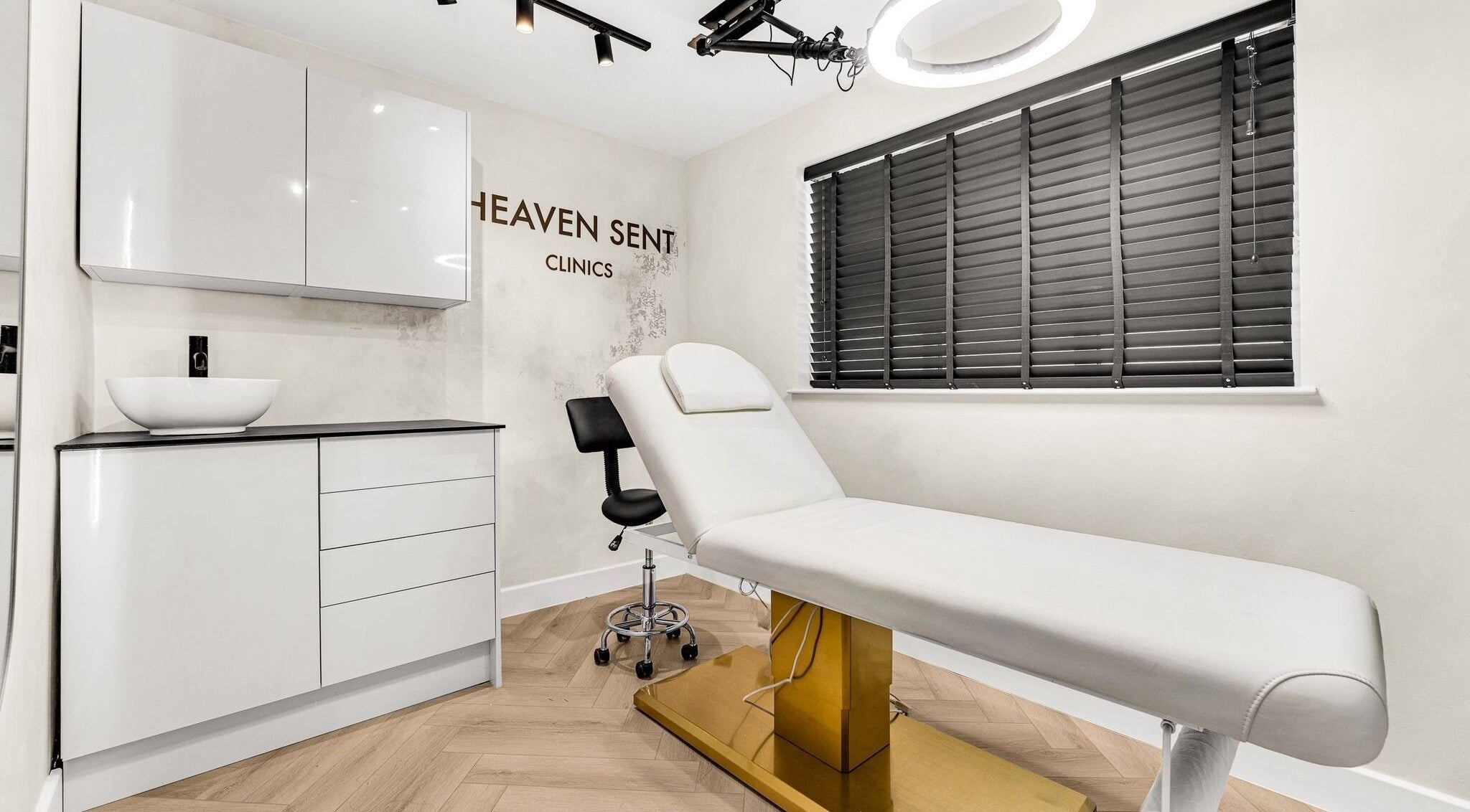 Elegant treatment room at Rosy Glow Aesthetics in Wilmslow, England, GB featuring a sleek white bed.