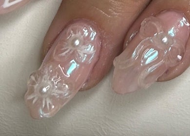 Intricate pearl nails by Klawed by Karissa, Vancouver, British Columbia, CA showcase detailed floral art.