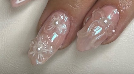 Intricate pearl nails by Klawed by Karissa, Vancouver, British Columbia, CA showcase detailed floral art.