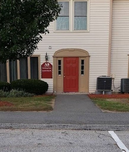 Entrance of Kokoro Therapeutics in Londonderry, New Hampshire, US with red door and lush greenery.