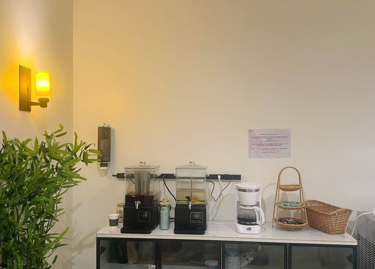 Refreshment area at Beng Teng Spa in Tumon, GU, featuring dispensers and a coffee maker.