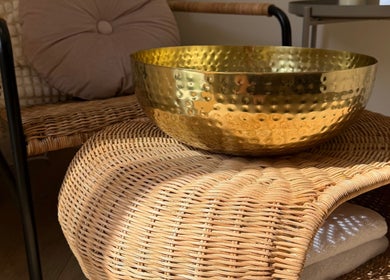 Golden bowl on wicker chair at ML BEAU-TY, Waterlooville, England, GB enhancing a serene ambiance.