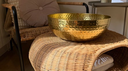 Relaxing decor with a golden bowl and wicker chair at ML BEAU-TY in Waterlooville, England, GB.