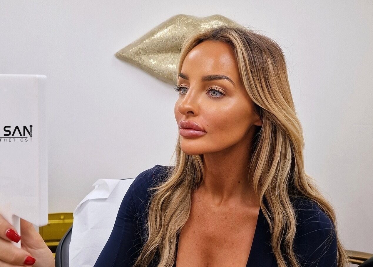 Woman admiring her look in a mirror at By San Aesthetics, Telford, England, GB.