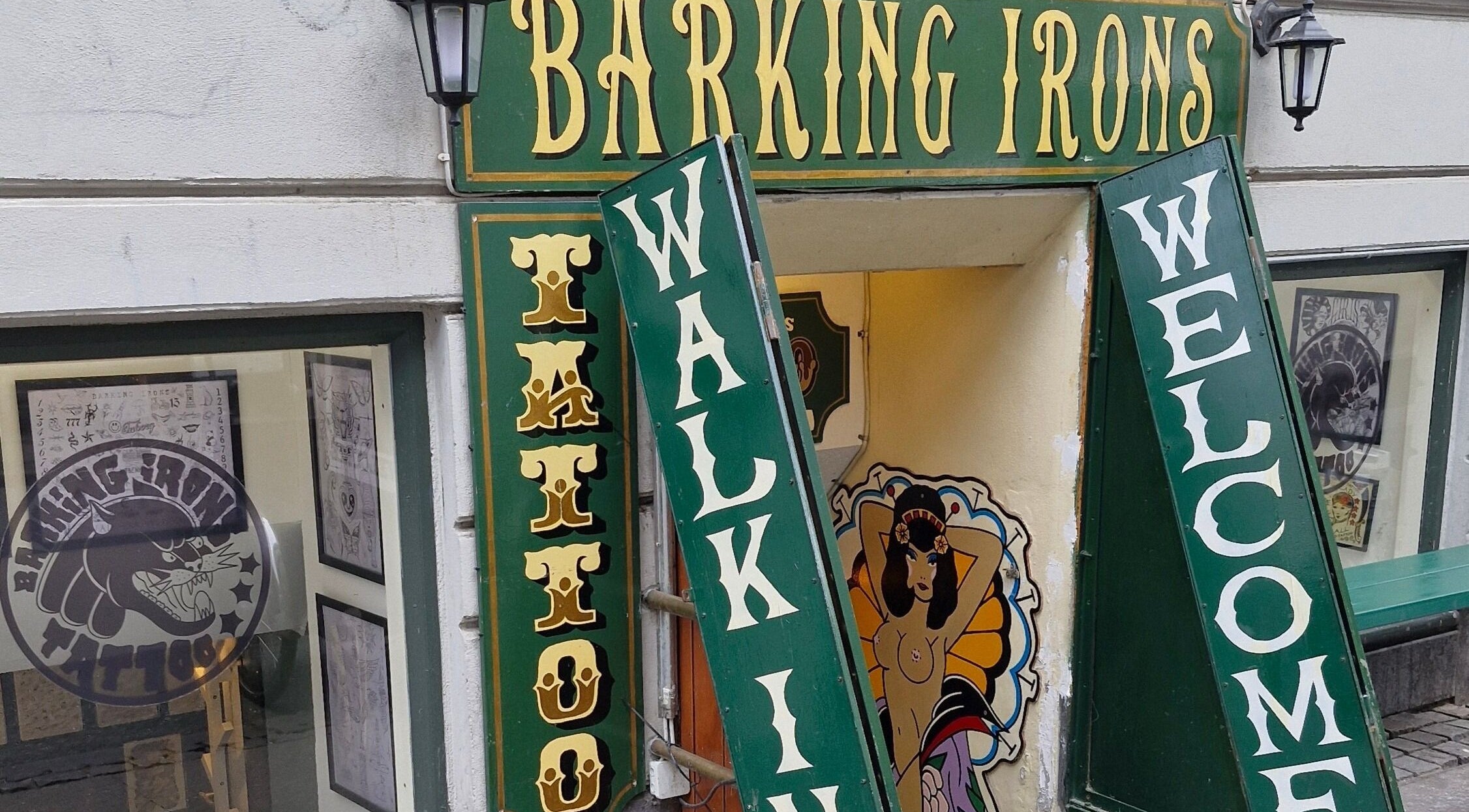 Barking Irons Tattoo, København, Denmark, DK indgang med skilt og kunstneriske designs.
