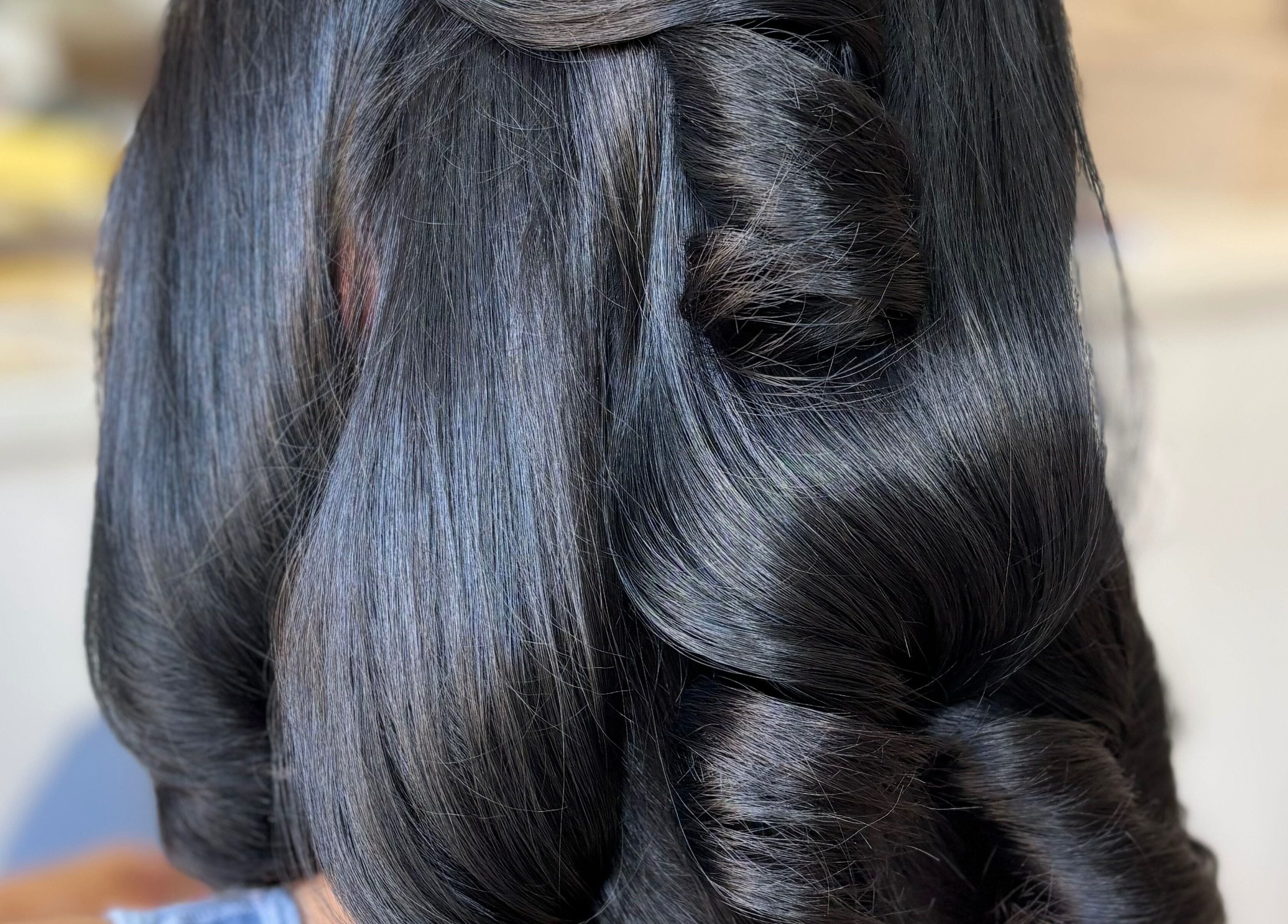 Sleek hairstyle with elegant curls at Bouncy Blowbar, Rochford, England, GB.